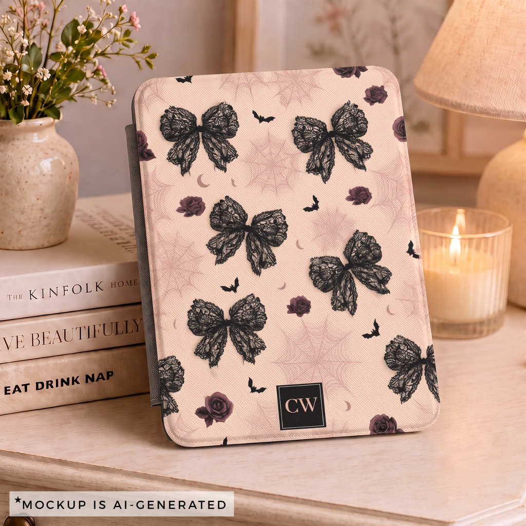 Close-up of gothic coquette Kindle cover - detailed black lace bow pattern with dark roses bats and crescent moons on blush